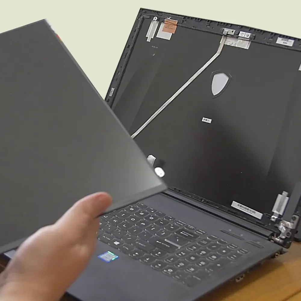 Un técnico cambiando la pantalla rota de un ordenador portatil